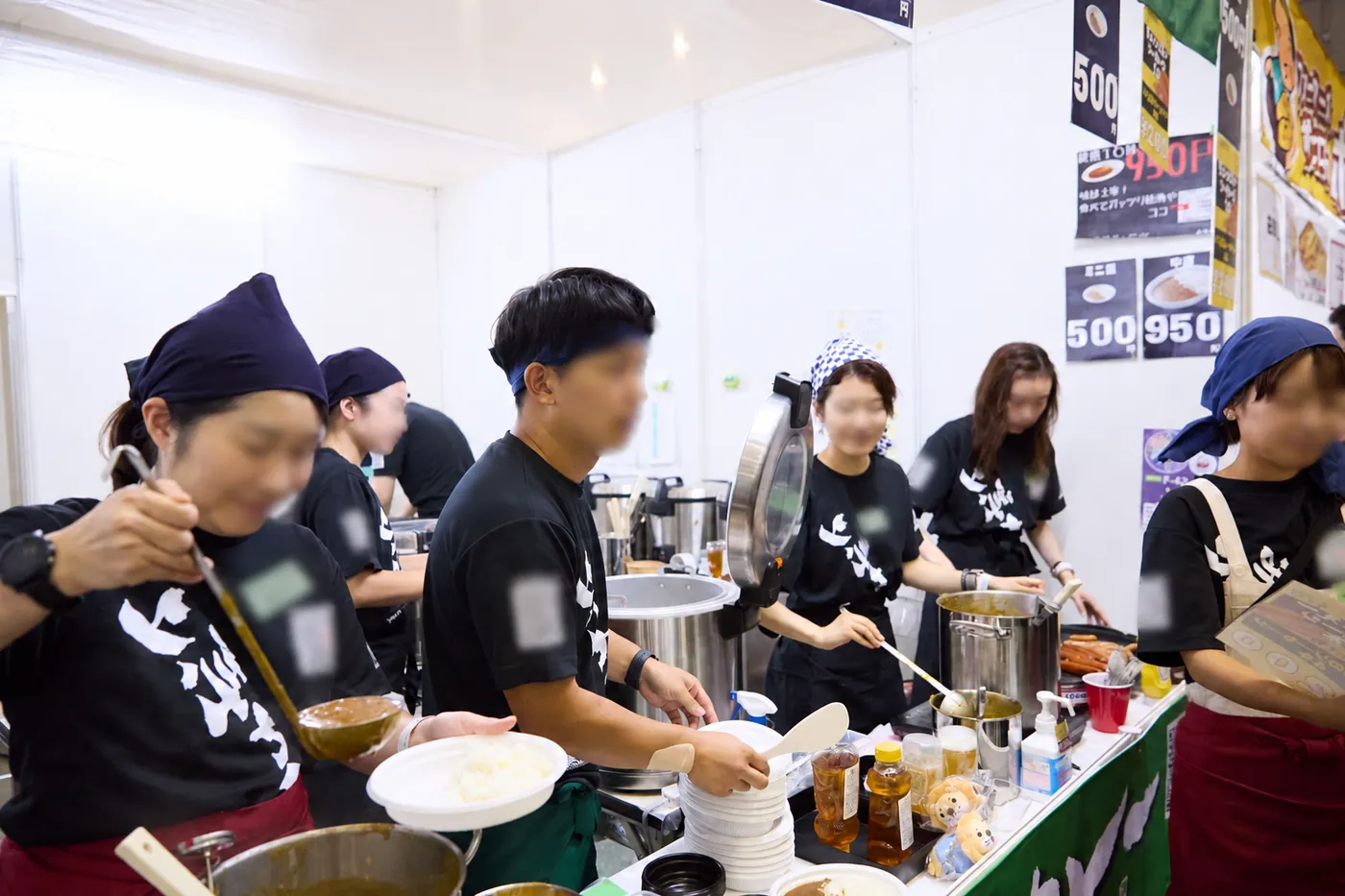 キッチンブースで仲間と調理する出店チーム