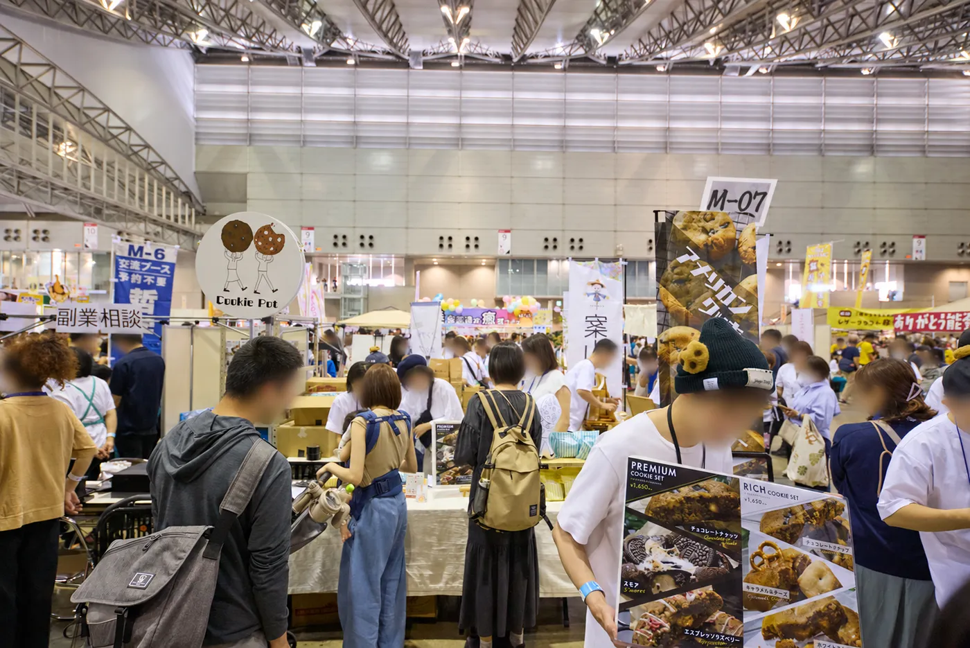 焼き菓子などの商品が並び、接客する出店者と来場者でにぎわう販売エリア