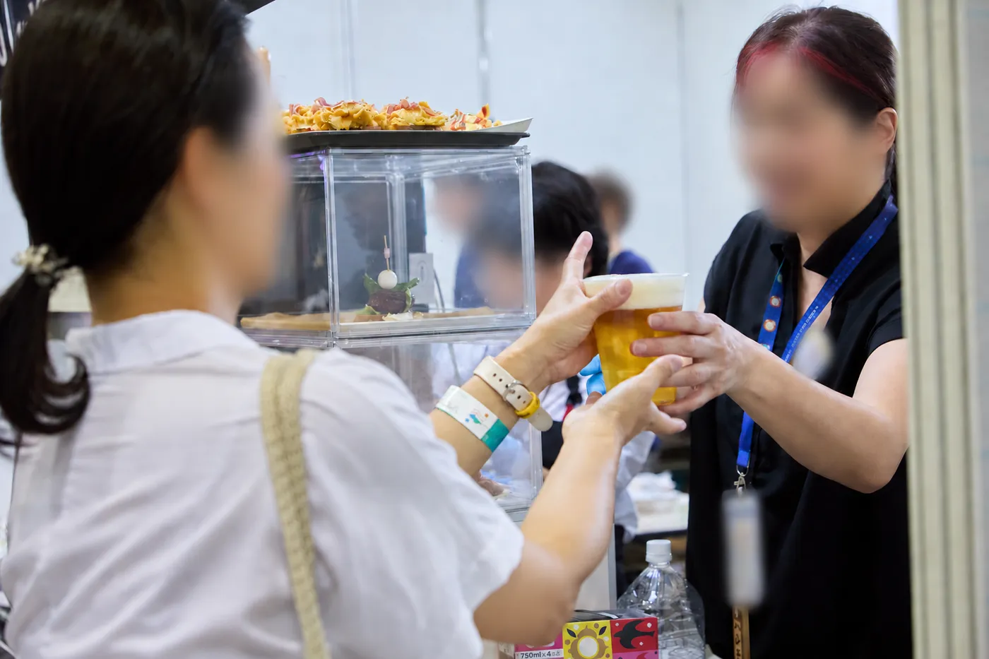 飲食ブースで来場者にドリンクを手渡す出店者