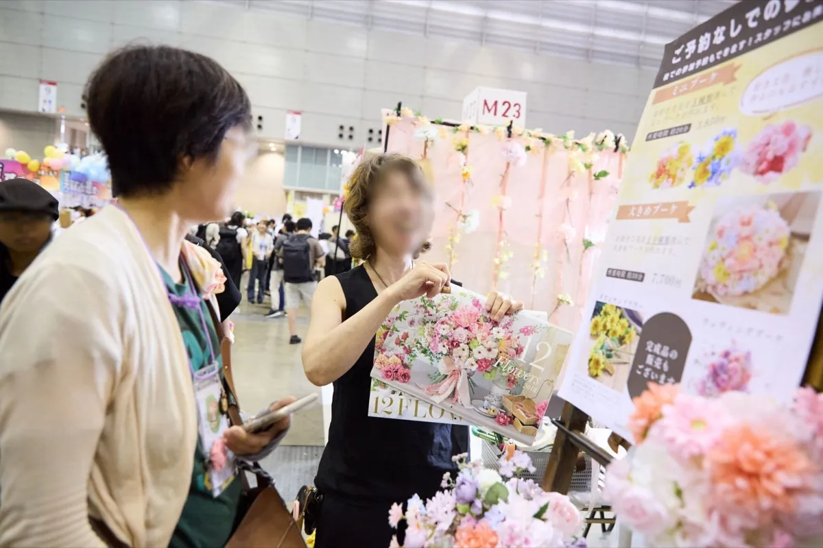 ハンドメイドの花を並べたオープンなブースで接客する様子